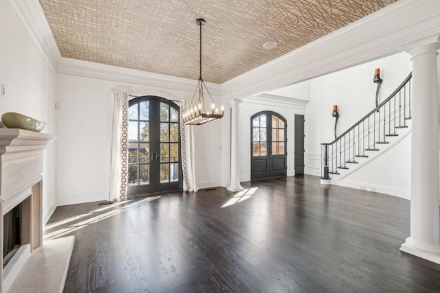 foyer entrance featuring an ornate ceiling, decorative columns, stairway, french doors, and ornamental molding