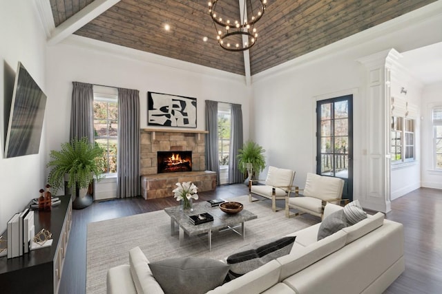 living area with an inviting chandelier, high vaulted ceiling, a fireplace, and wood finished floors
