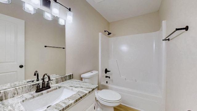 bathroom with toilet, wood finished floors, vanity, and washtub / shower combination