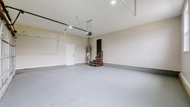 garage with gas water heater, baseboards, and a garage door opener
