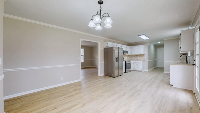 kitchen featuring a notable chandelier, backsplash, a sink, light wood finished floors, and stainless steel appliances