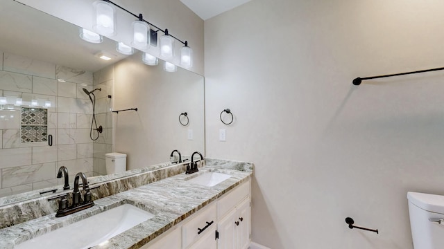 full bath with toilet, a sink, double vanity, and a shower stall