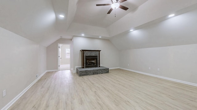 unfurnished living room featuring a ceiling fan, baseboards, light wood-style floors, and vaulted ceiling