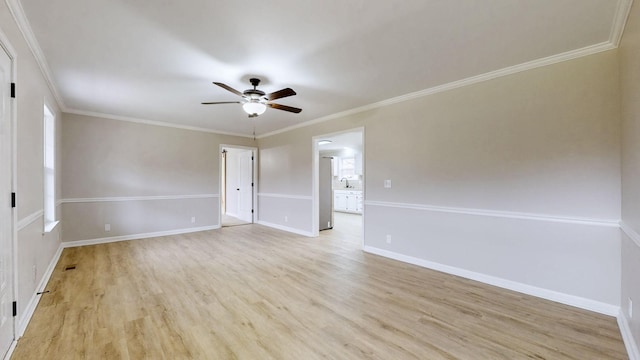unfurnished room with baseboards, crown molding, light wood-style flooring, and a ceiling fan