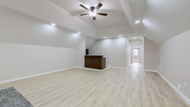 bonus room featuring lofted ceiling, visible vents, light wood-style flooring, and a ceiling fan