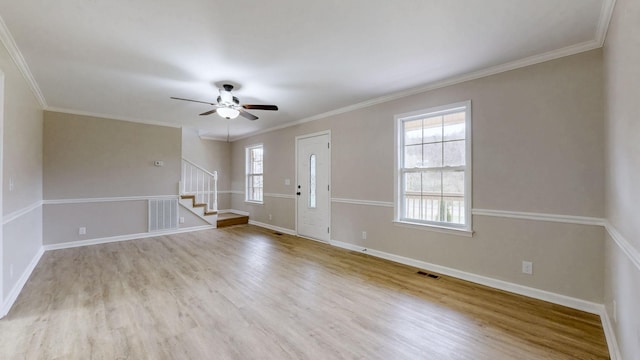 foyer entrance with wood finished floors, stairway, ceiling fan, and visible vents