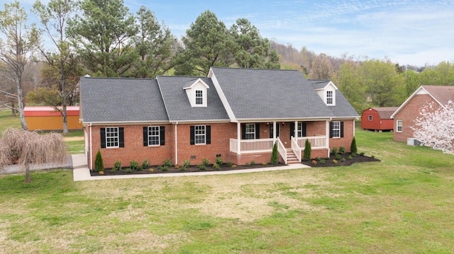 cape cod home with roof with shingles, crawl space, a front lawn, brick siding, and a porch