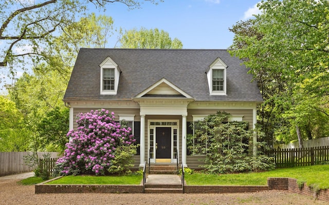 new england style home with fence and roof with shingles