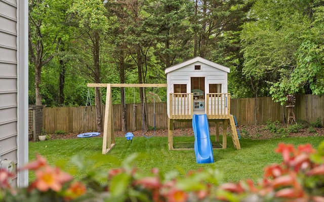 view of play area featuring a fenced backyard, an outbuilding, and a yard