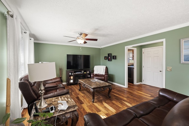 living area with a textured ceiling, baseboards, ceiling fan, wood finished floors, and ornamental molding