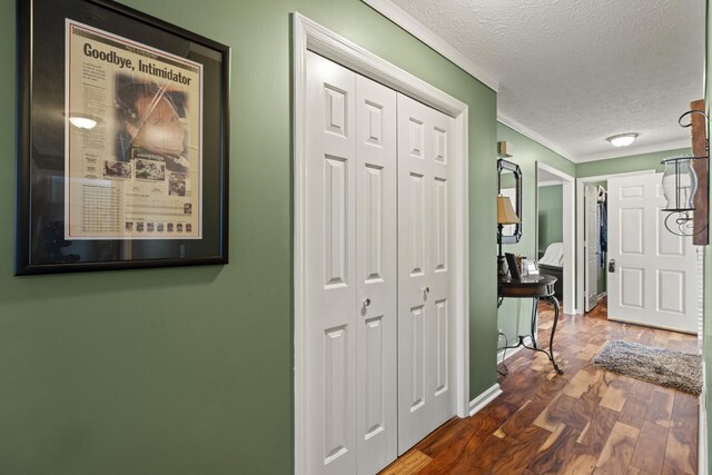 hall featuring crown molding, wood finished floors, and a textured ceiling