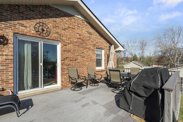 wooden deck with grilling area and outdoor dining area
