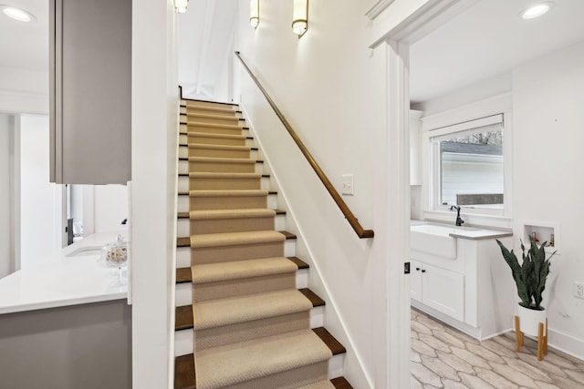 stairway with marble finish floor, baseboards, and recessed lighting