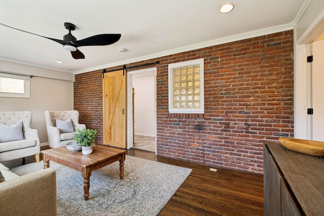 living area with a barn door, crown molding, brick wall, and dark wood-type flooring
