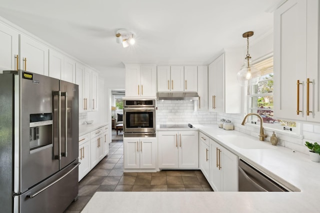 kitchen with white cabinetry, stainless steel appliances, under cabinet range hood, backsplash, and a sink