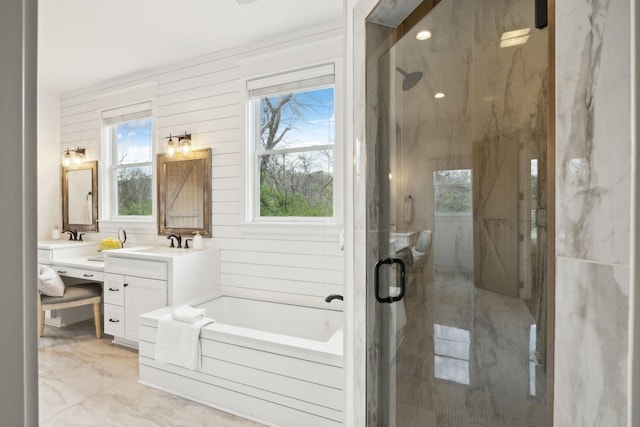 full bath featuring a sink, a shower stall, a bath, marble finish floor, and double vanity