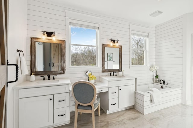 bathroom with visible vents, wood walls, a sink, and two vanities