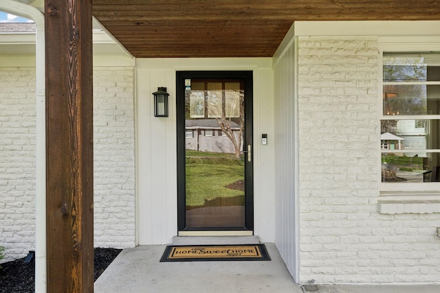 doorway to property with brick siding