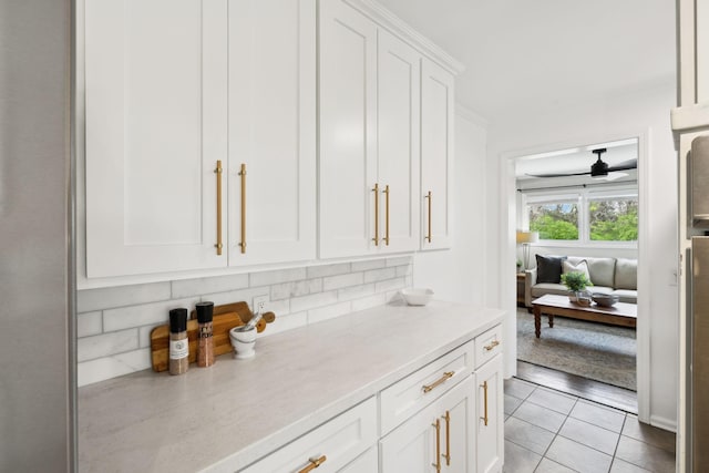 kitchen featuring white cabinetry, light tile patterned floors, tasteful backsplash, and ceiling fan