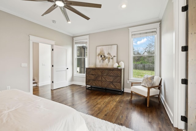 bedroom featuring baseboards, crown molding, wood finished floors, and a ceiling fan