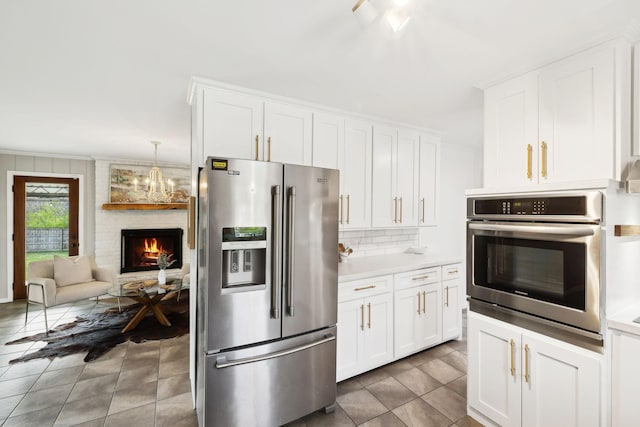 kitchen with white cabinetry, light countertops, tasteful backsplash, stainless steel appliances, and tile patterned floors
