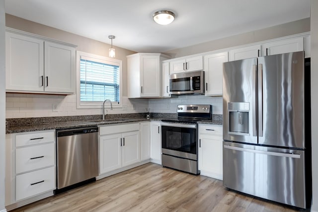 kitchen featuring a sink, white cabinetry, decorative backsplash, and appliances with stainless steel finishes