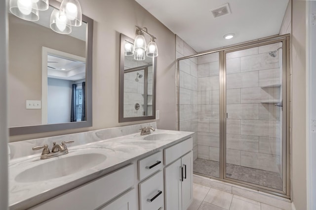 full bathroom featuring visible vents, a sink, double vanity, and a shower stall