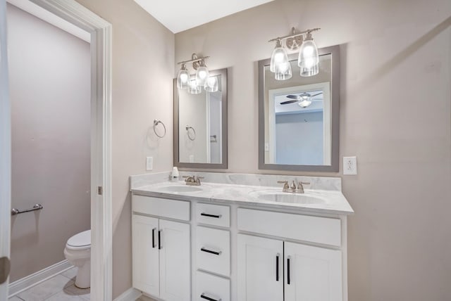 bathroom with double vanity, toilet, a sink, and tile patterned floors