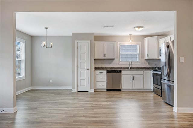 kitchen with visible vents, stainless steel appliances, tasteful backsplash, white cabinetry, and pendant lighting