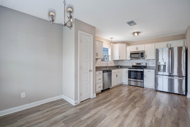 kitchen featuring a notable chandelier, tasteful backsplash, visible vents, stainless steel appliances, and dark countertops