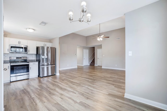 kitchen featuring white cabinets, baseboards, stainless steel appliances, ceiling fan with notable chandelier, and backsplash