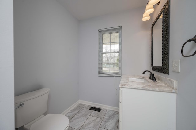 bathroom featuring baseboards, marble finish floor, toilet, and vanity