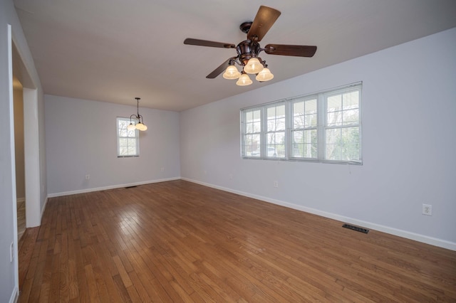 spare room featuring baseboards, visible vents, ceiling fan, and hardwood / wood-style flooring