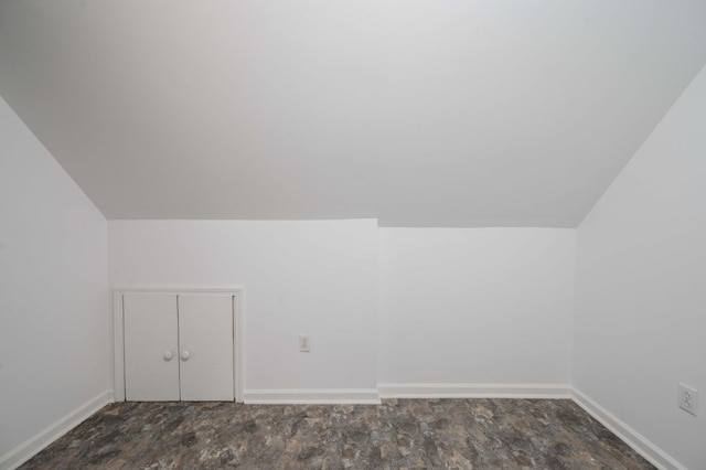 additional living space featuring baseboards and lofted ceiling
