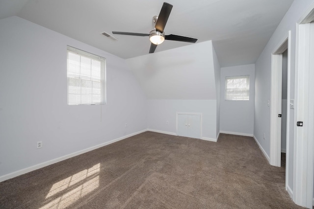additional living space with visible vents, baseboards, a ceiling fan, carpet floors, and vaulted ceiling