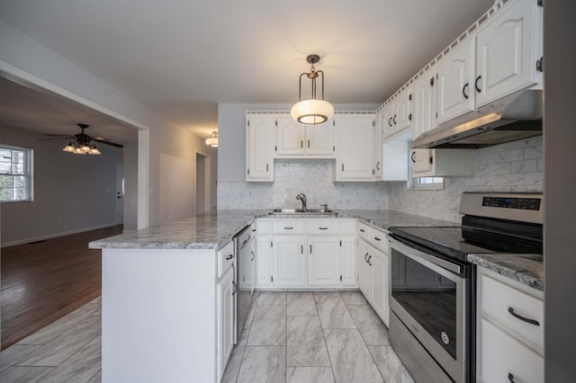 kitchen featuring white cabinetry, under cabinet range hood, a sink, a peninsula, and appliances with stainless steel finishes