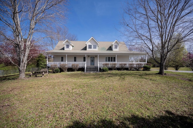 farmhouse-style home with a front lawn, metal roof, and a porch