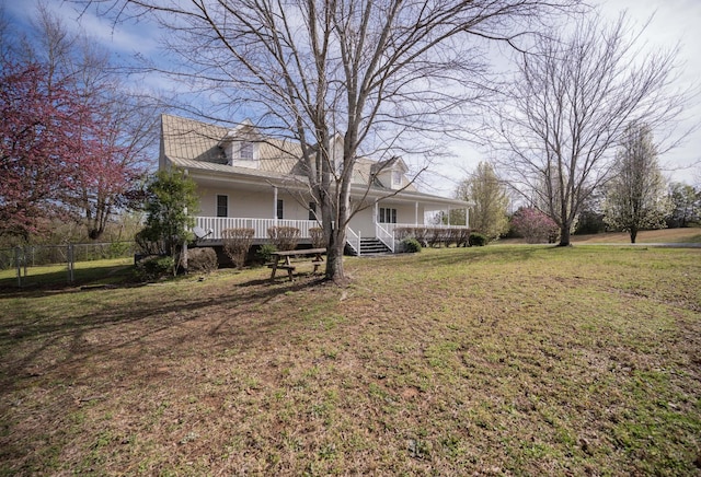 view of yard featuring covered porch and fence