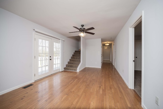 foyer entrance featuring stairway, french doors, light wood finished floors, visible vents, and ceiling fan