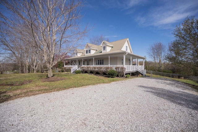 view of front facade featuring covered porch, fence, and a front lawn