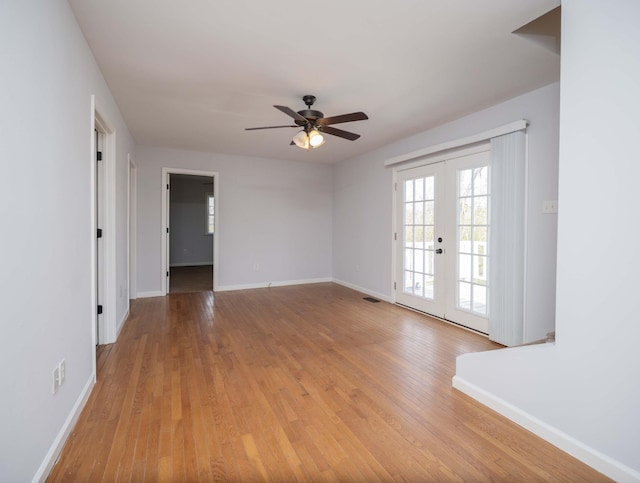 unfurnished room with visible vents, baseboards, a ceiling fan, light wood-style floors, and french doors
