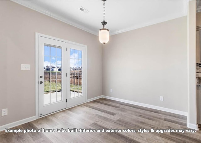 interior space with baseboards, visible vents, wood finished floors, and ornamental molding