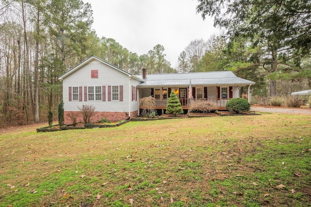 single story home with covered porch, a chimney, and a front lawn