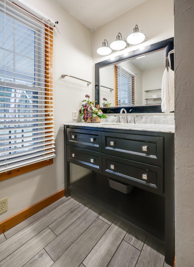 bathroom with vanity, baseboards, and wood finished floors