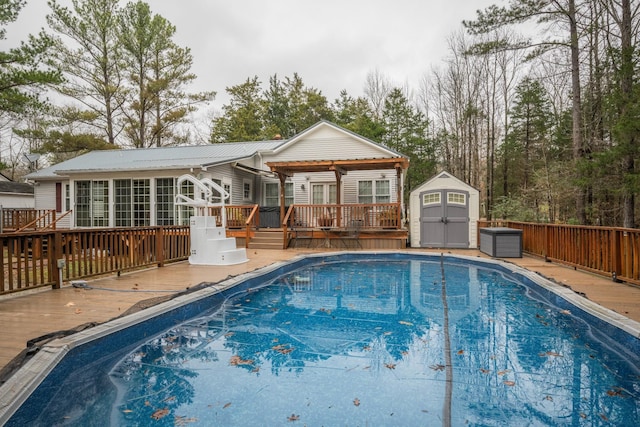 rear view of house featuring an outdoor structure, a fenced in pool, a wooden deck, and a storage shed