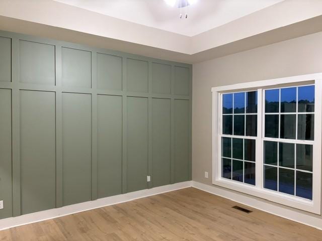 spare room featuring baseboards, light wood finished floors, and visible vents