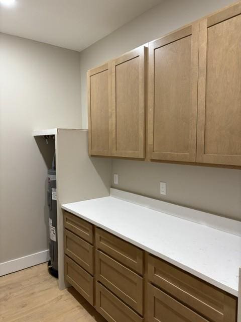 kitchen with light wood-style floors, light countertops, and baseboards
