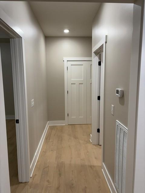 hallway featuring recessed lighting, baseboards, light wood finished floors, and visible vents