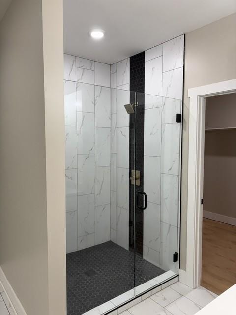 bathroom with recessed lighting, marble finish floor, and a stall shower