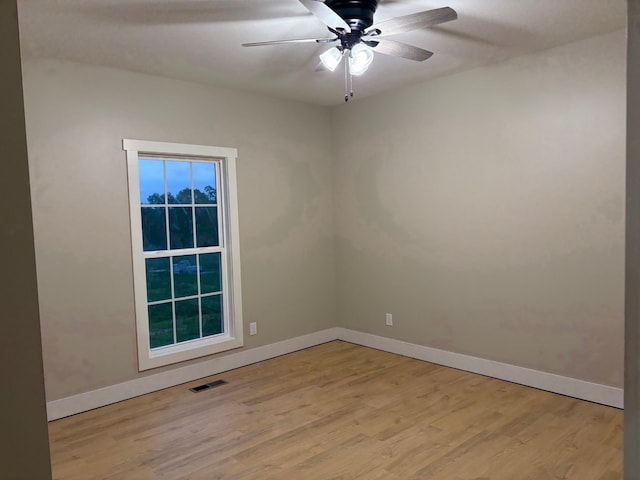 unfurnished room featuring baseboards, a ceiling fan, light wood-type flooring, and visible vents